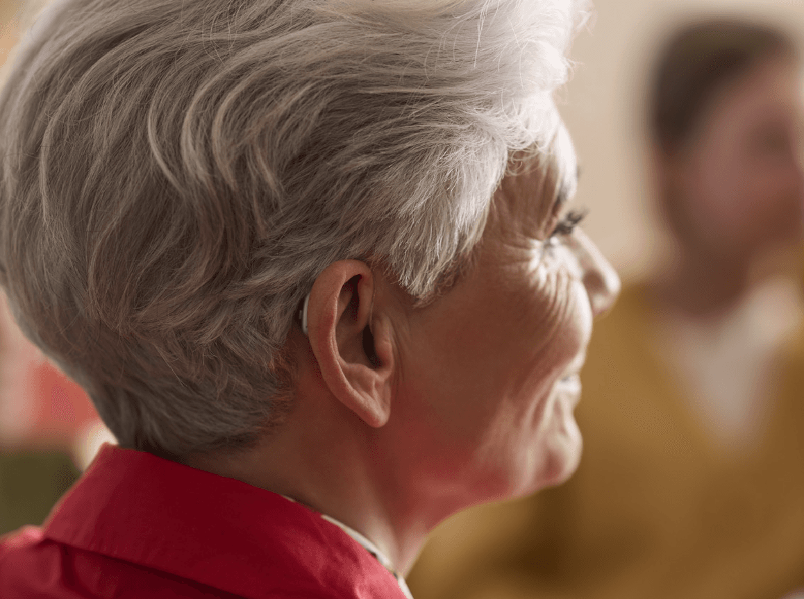 lady smiling with hearing aid in her ear